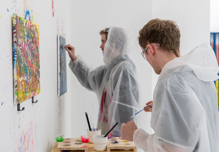  Two men painting on a canvas